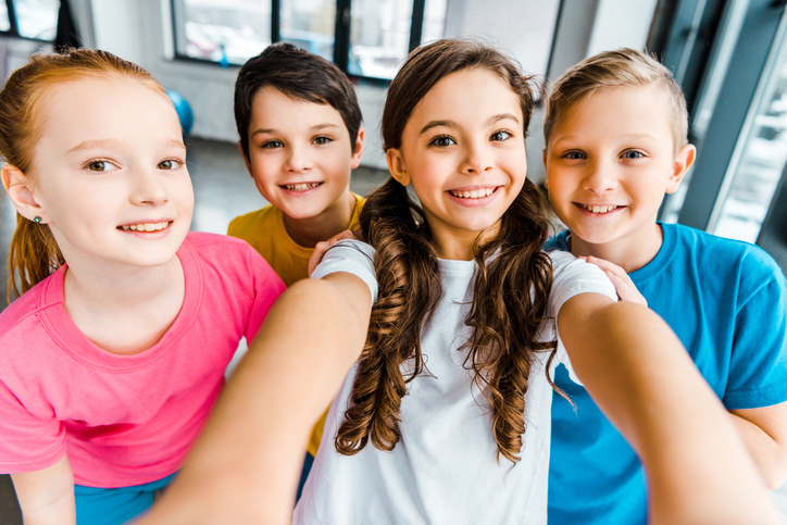 Excited Preteen Kids Laughing While Taking Selfie Together