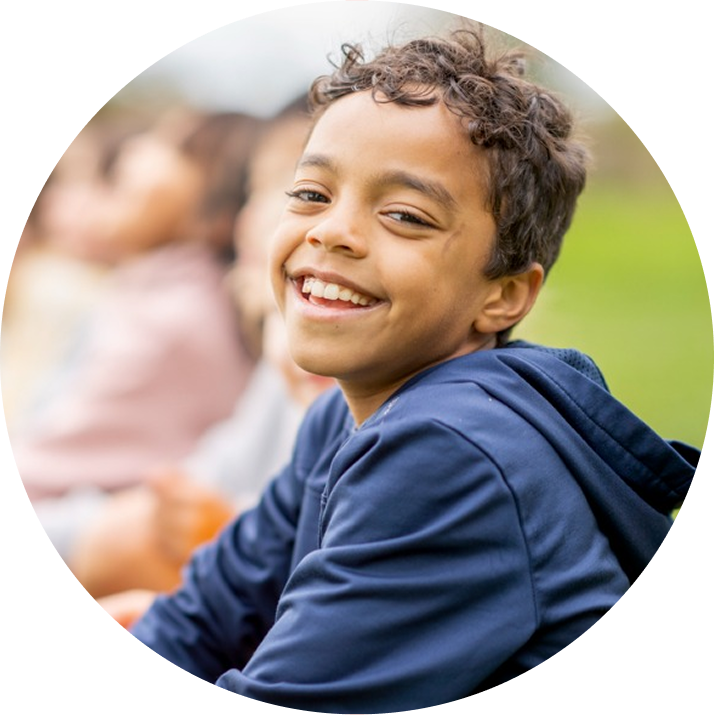 Smiling Boy Sitting Outdoors