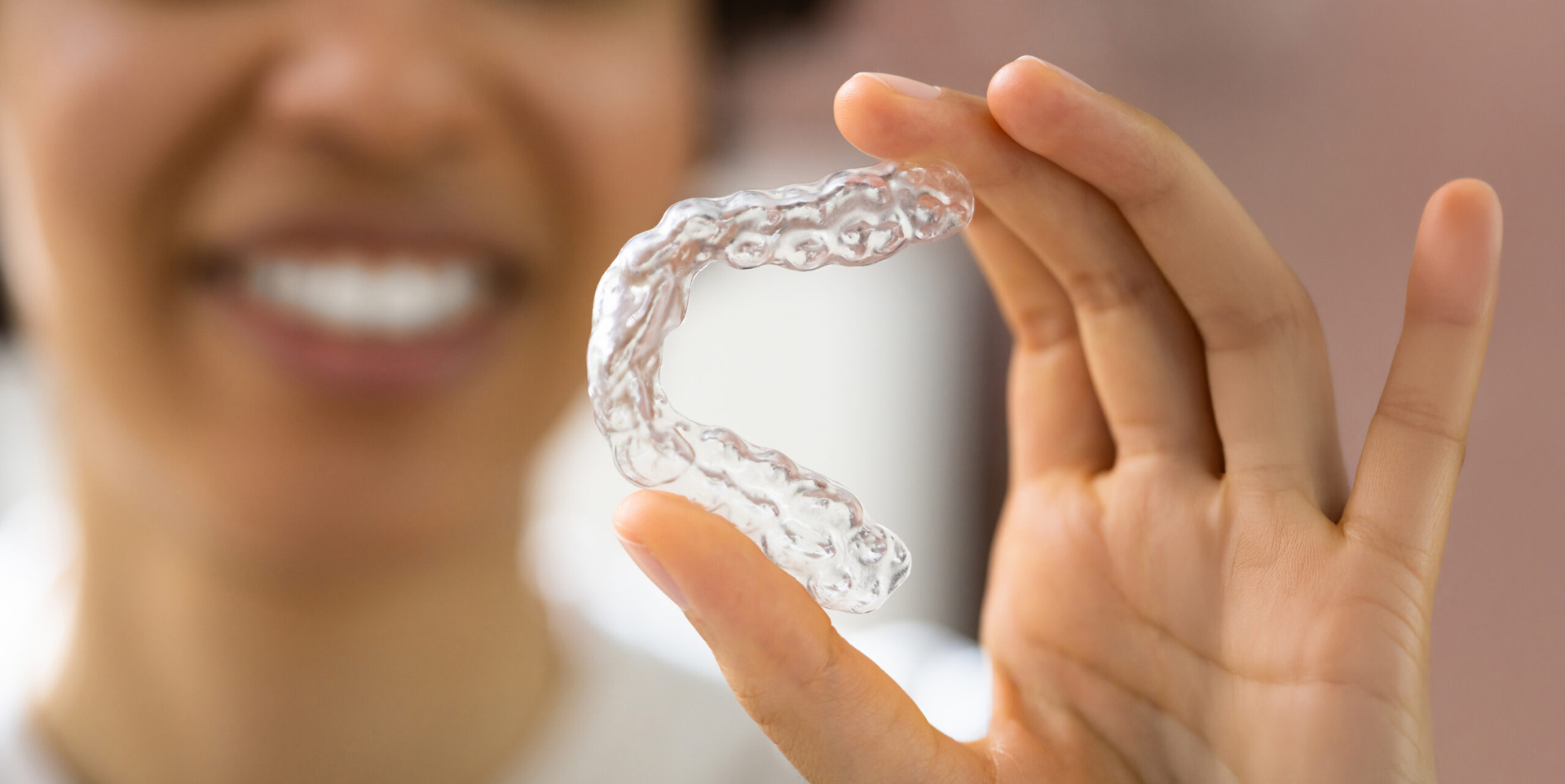 Close Up Of Woman Holding Clear Aligner