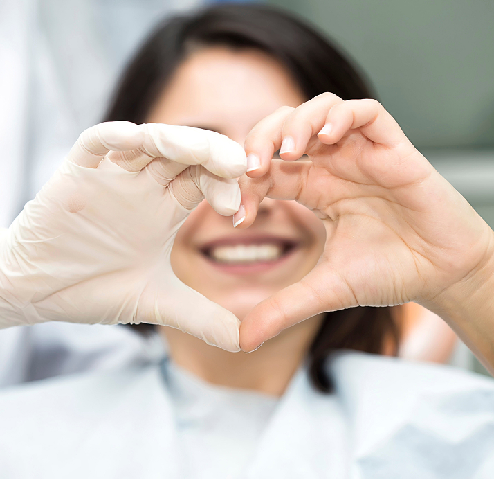 Smiling Woman And Orthodontist Making A Heart Shape With Their Hands