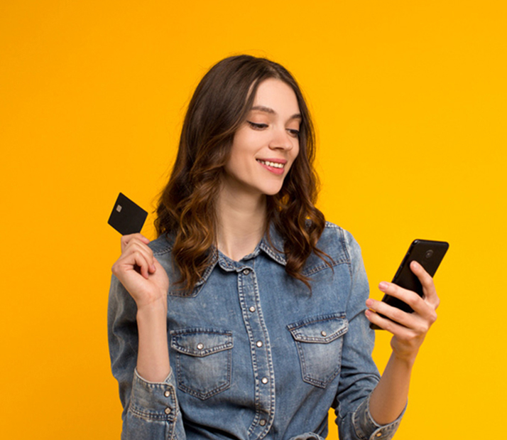 Smiling Woman Holding Credit Card And Looking At Phone