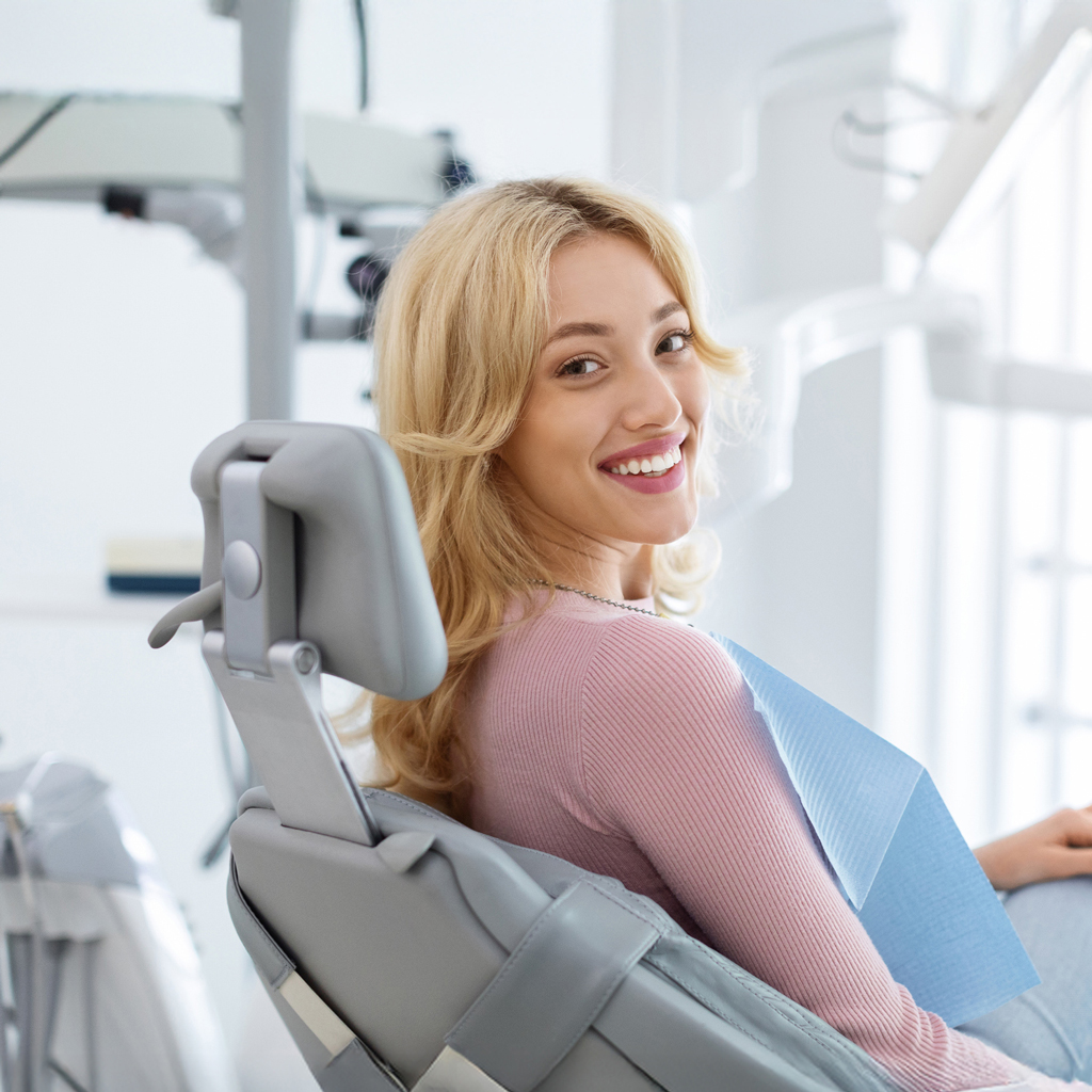 Smiling Woman Sitting In Orthodontist Chair