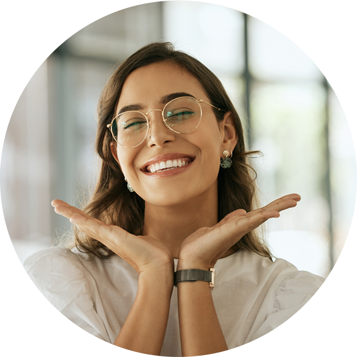 Smiling Woman Wearing Glasses With Eyes Closed And Hands Raised To Face