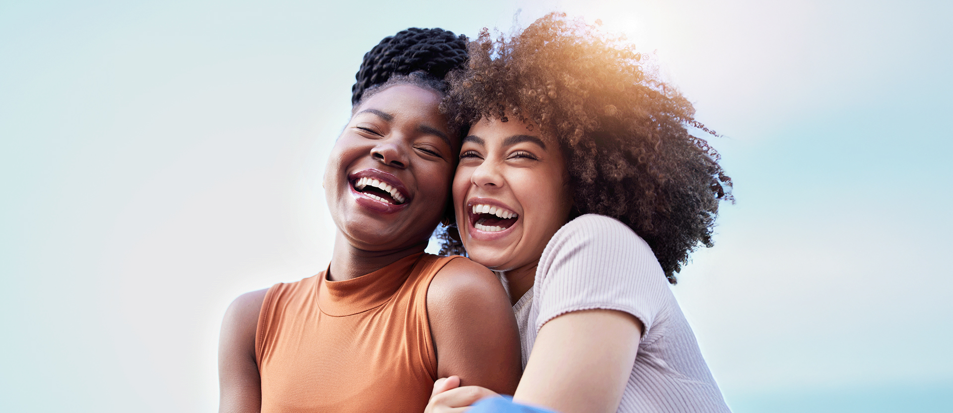 Two Smiling Women Hugging Each Other